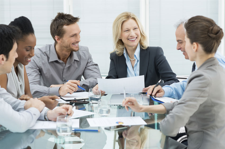Picture of a group of people sitting at a glass table in office wear