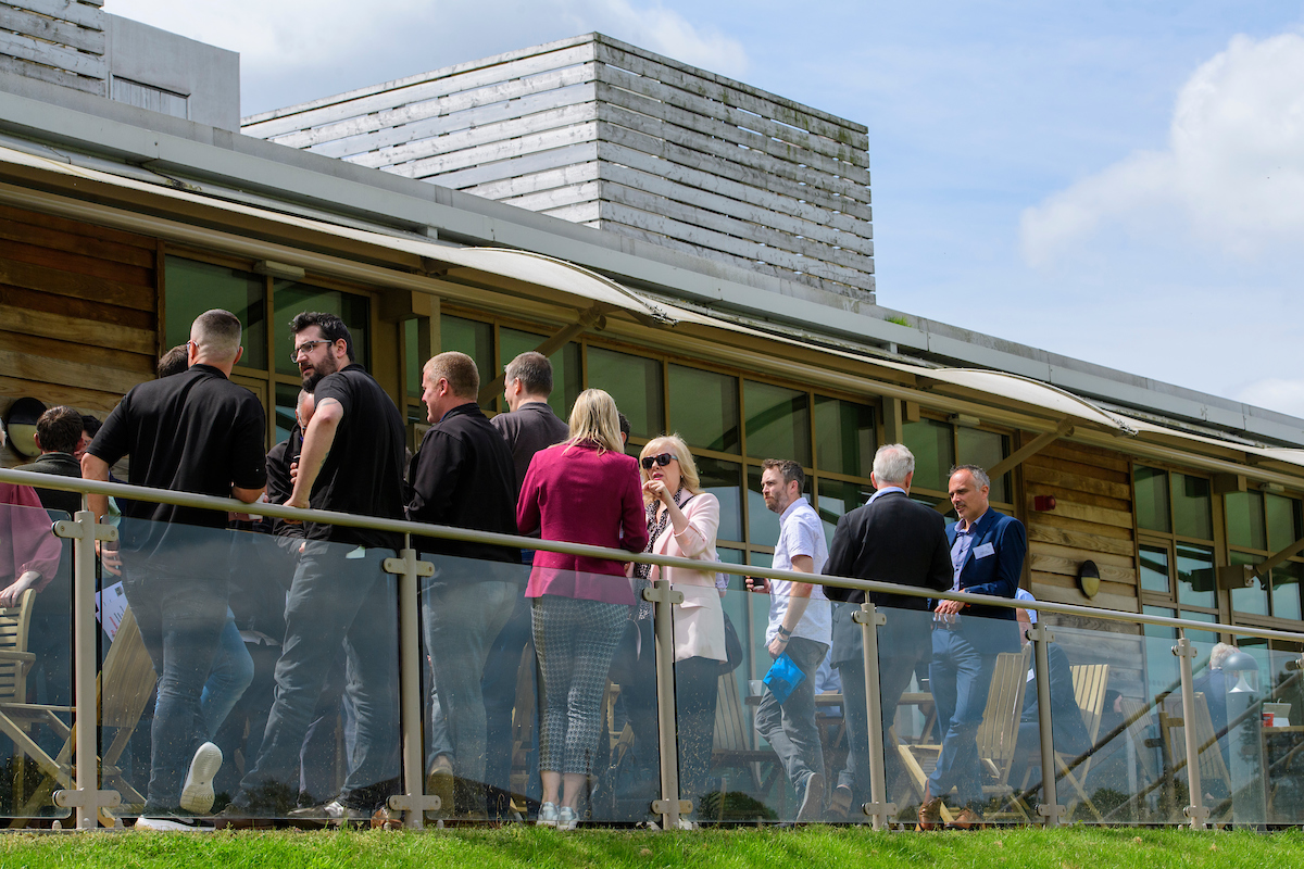An outdoor large gathering of people talking amongst themselves.